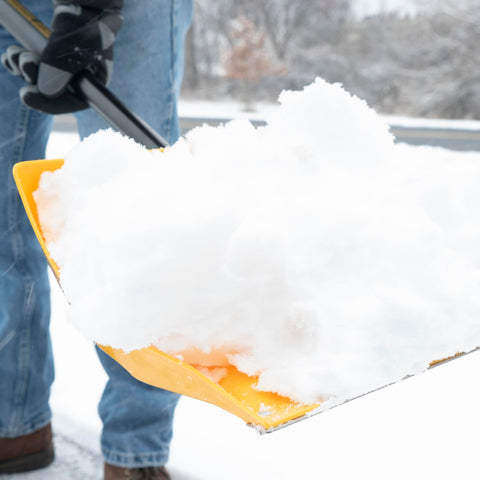 Shovel in use at a campsite next to a tent during winter conditions