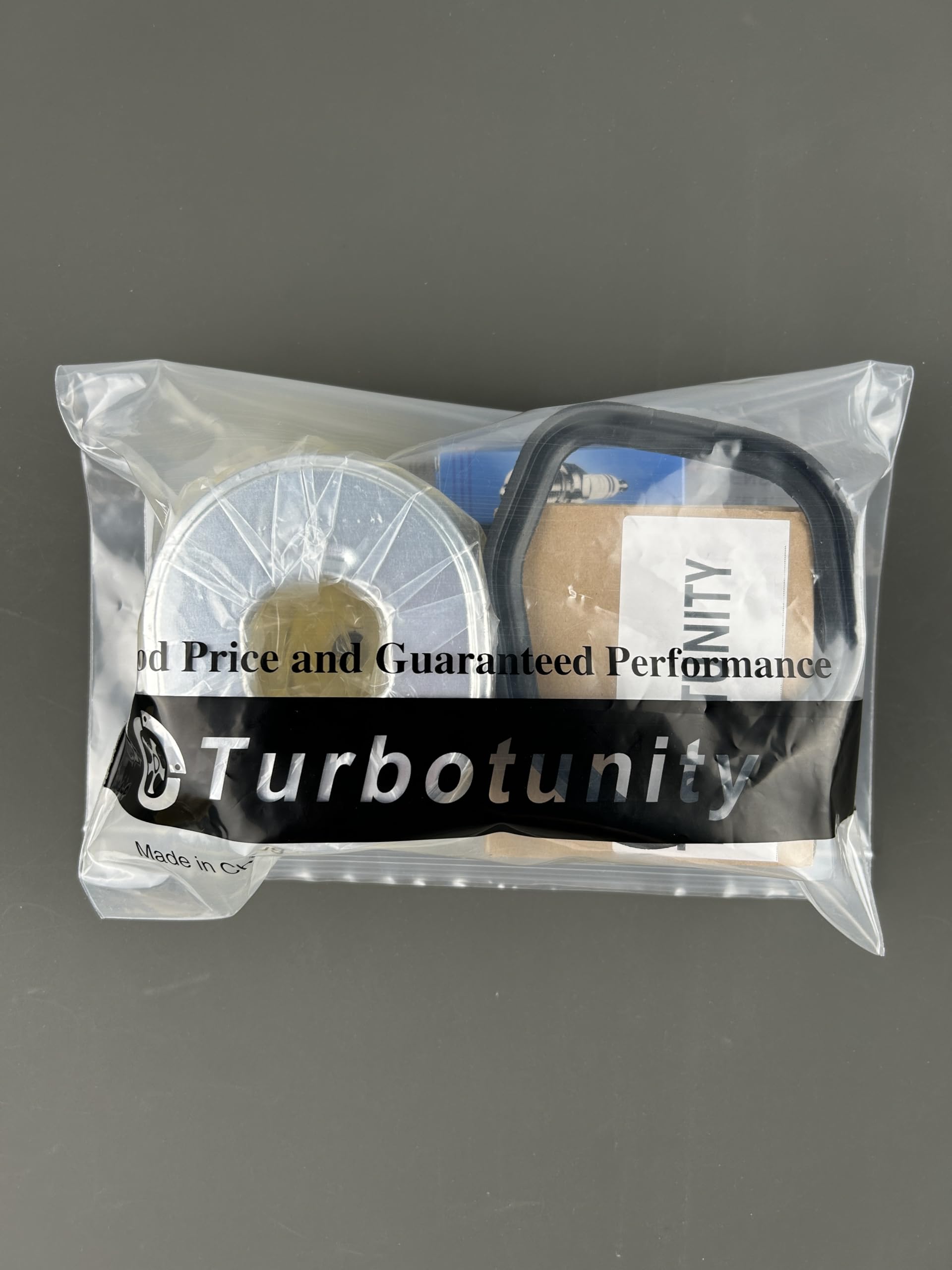 Turbotunity carburetor packaging contents including gaskets, filter, and spark plug.