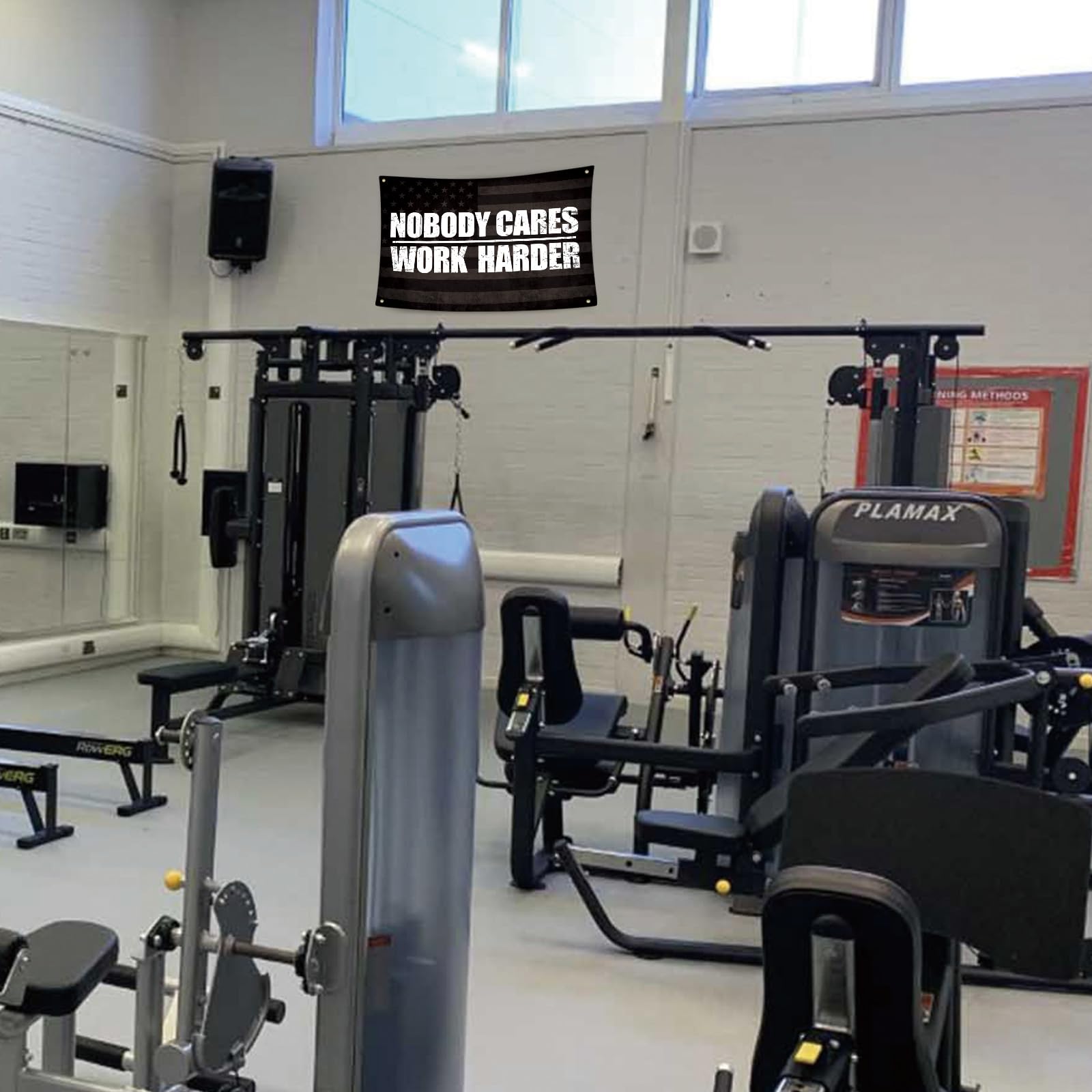 UCNMWBJ Nobody Cares Work Harder flag over squat rack adds visual focus.