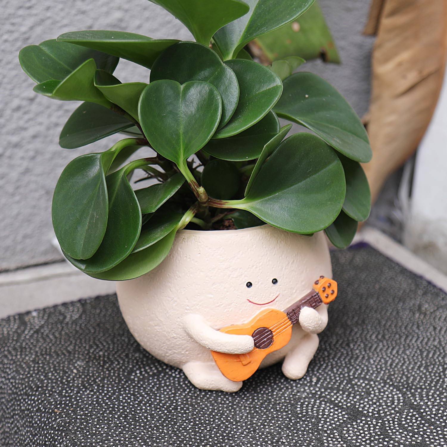 Closeup of UMESONG resin head planter showing cheerful design