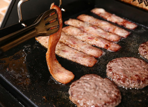 Utheer nano-ceramic griddle set up on a portable grill for outdoor cooking.