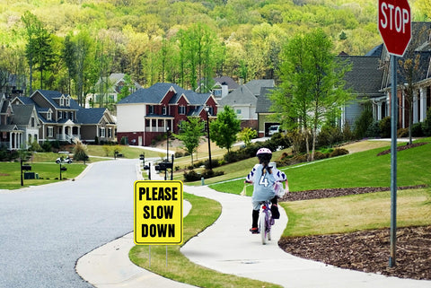 Venicor outdoor yard sign communicates please slow down to drivers.