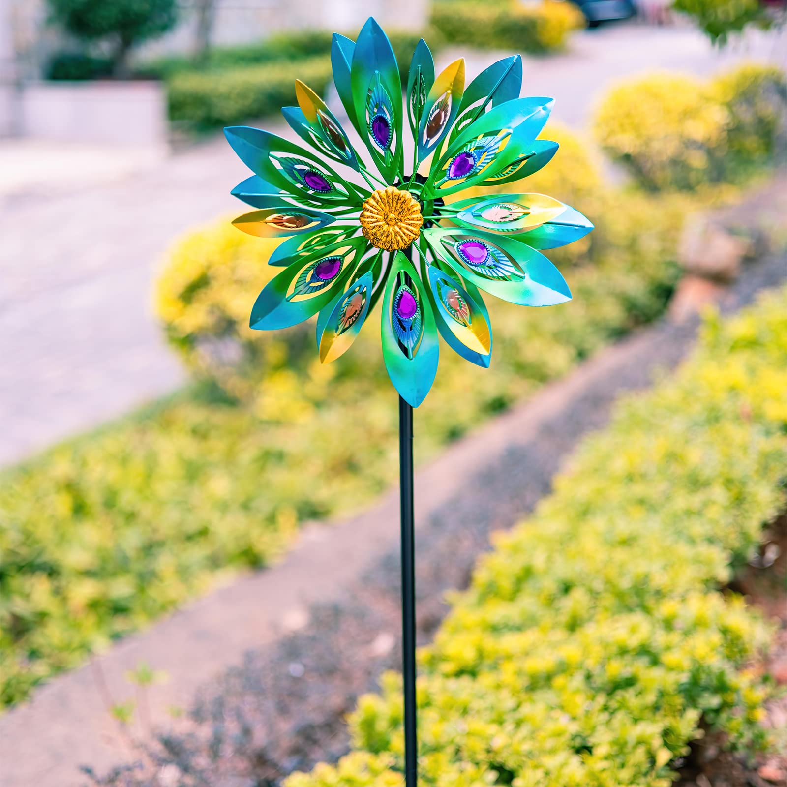 VEWOSTAR wind spinner viewed along garden path at sunset.