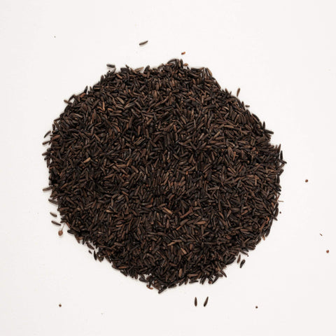 Wagner's Nyjer Seed being poured into a small-hole finch feeder.