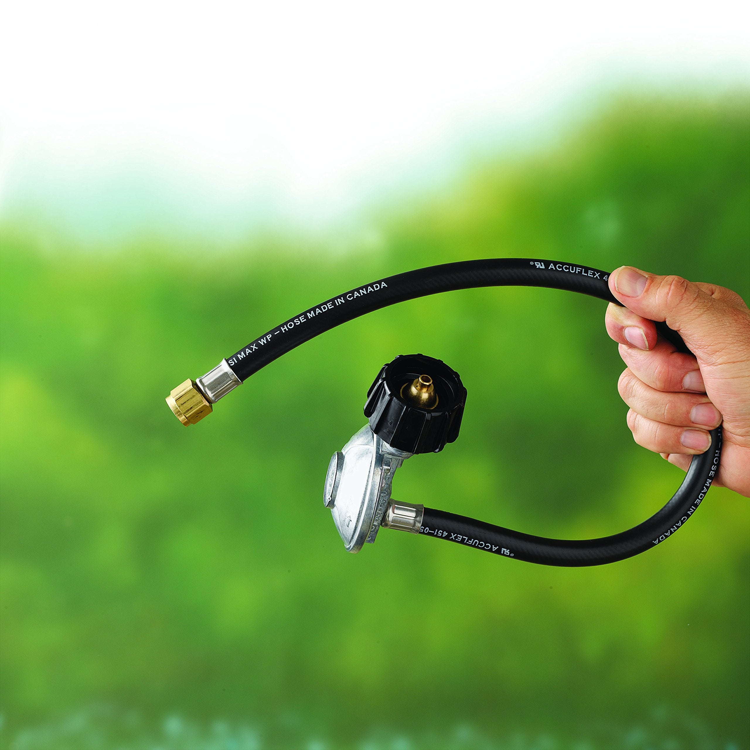 Close-up of hose and regulator ensuring airtight seal for safe grilling.