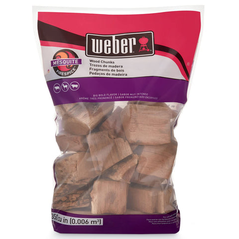 Weber Mesquite wood chunks releasing smoke to enhance grilled meats