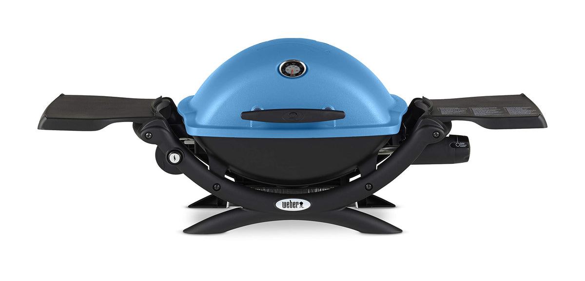 Weber Q1200 blue hood in portable setup for travel grilling.