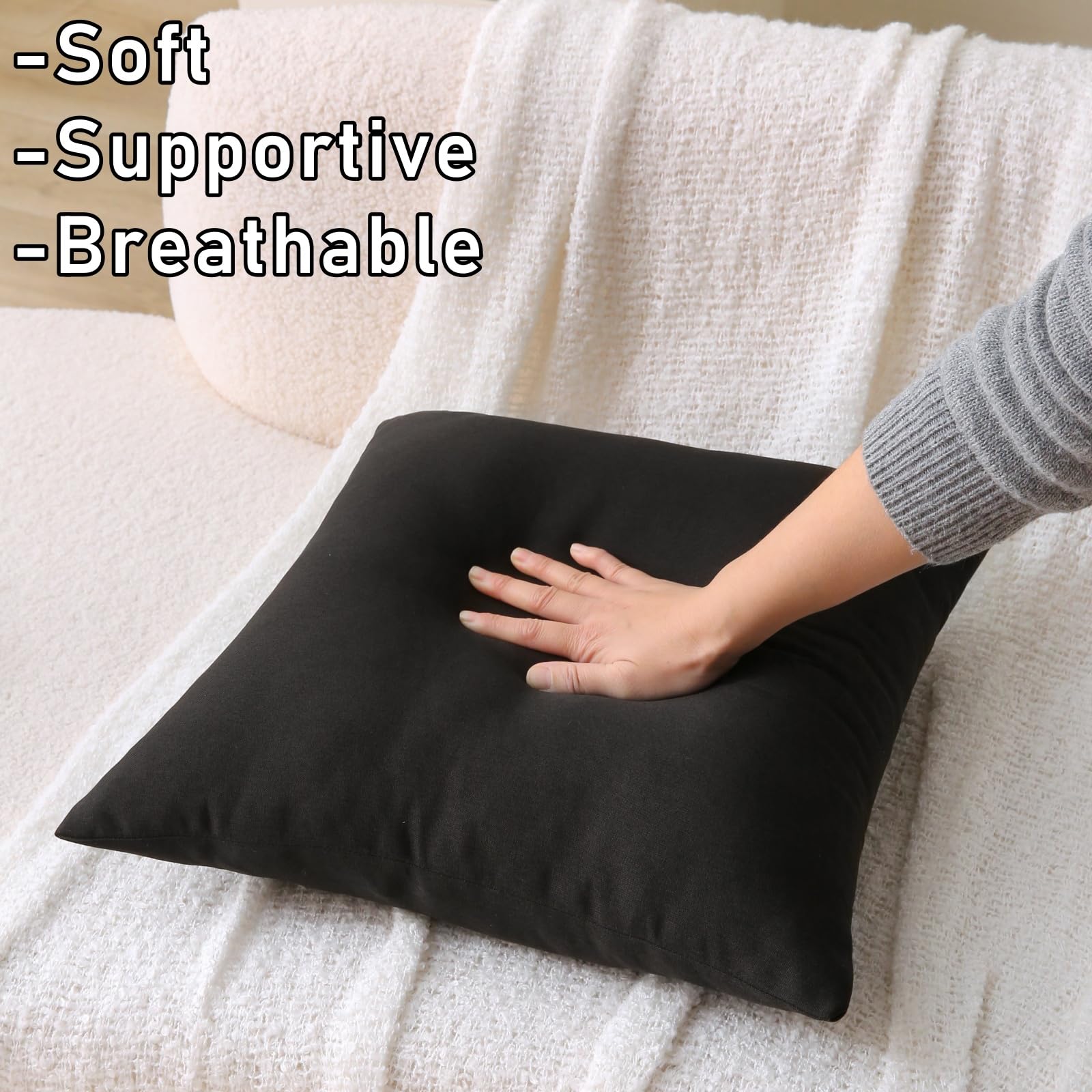 WHATWEARS black outdoor pillow on a garden sofa