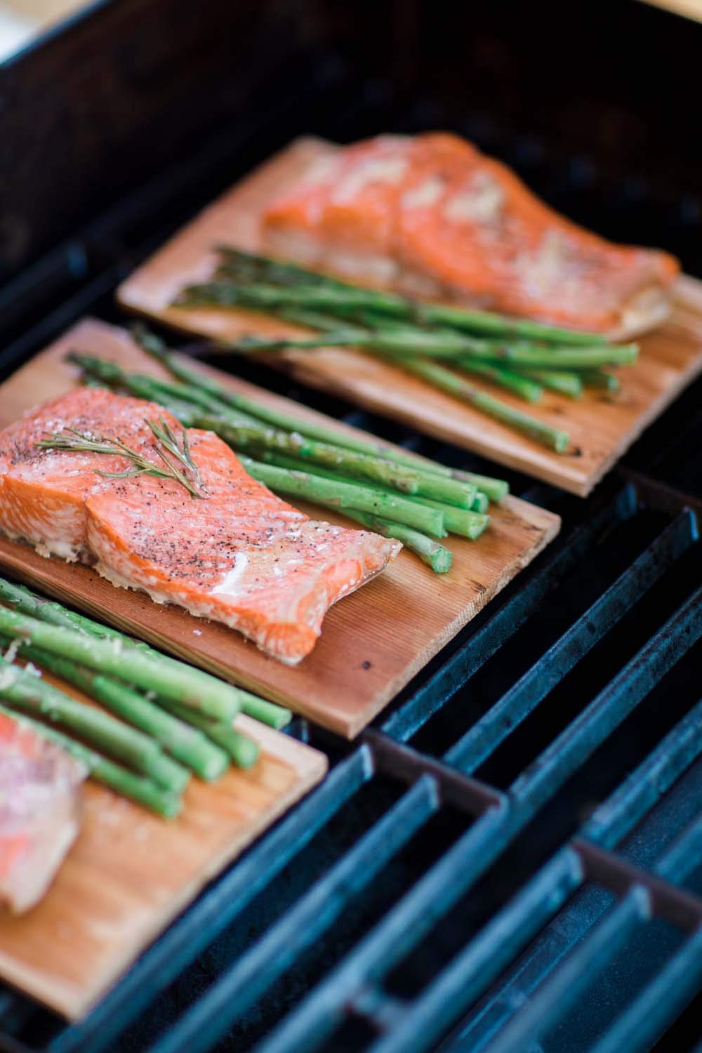 Wildwood Grilling salmon on cedar plank for enhanced flavor on grill.