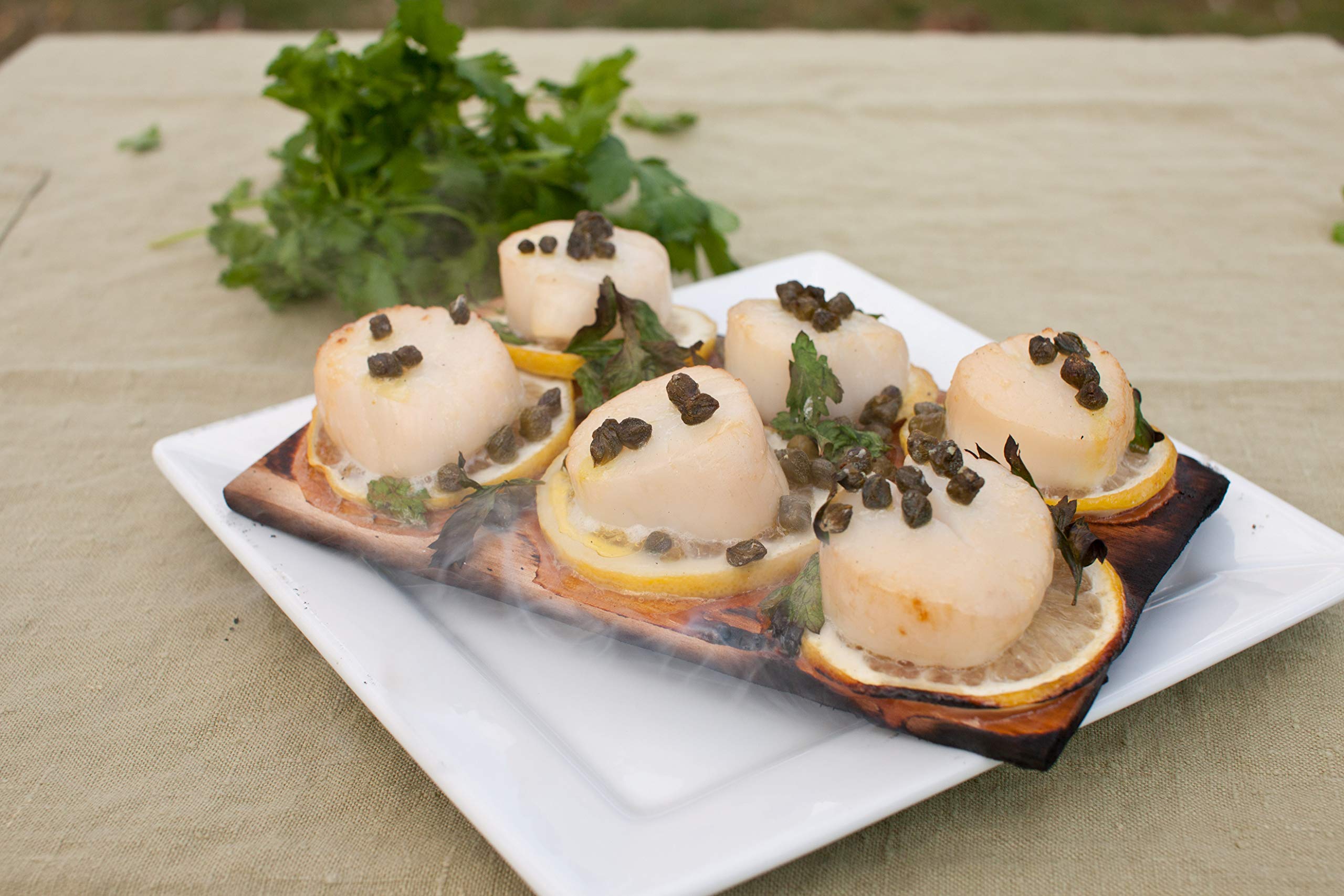 Wildwood Grilling salmon on cedar plank for flavorful, moist cooking.