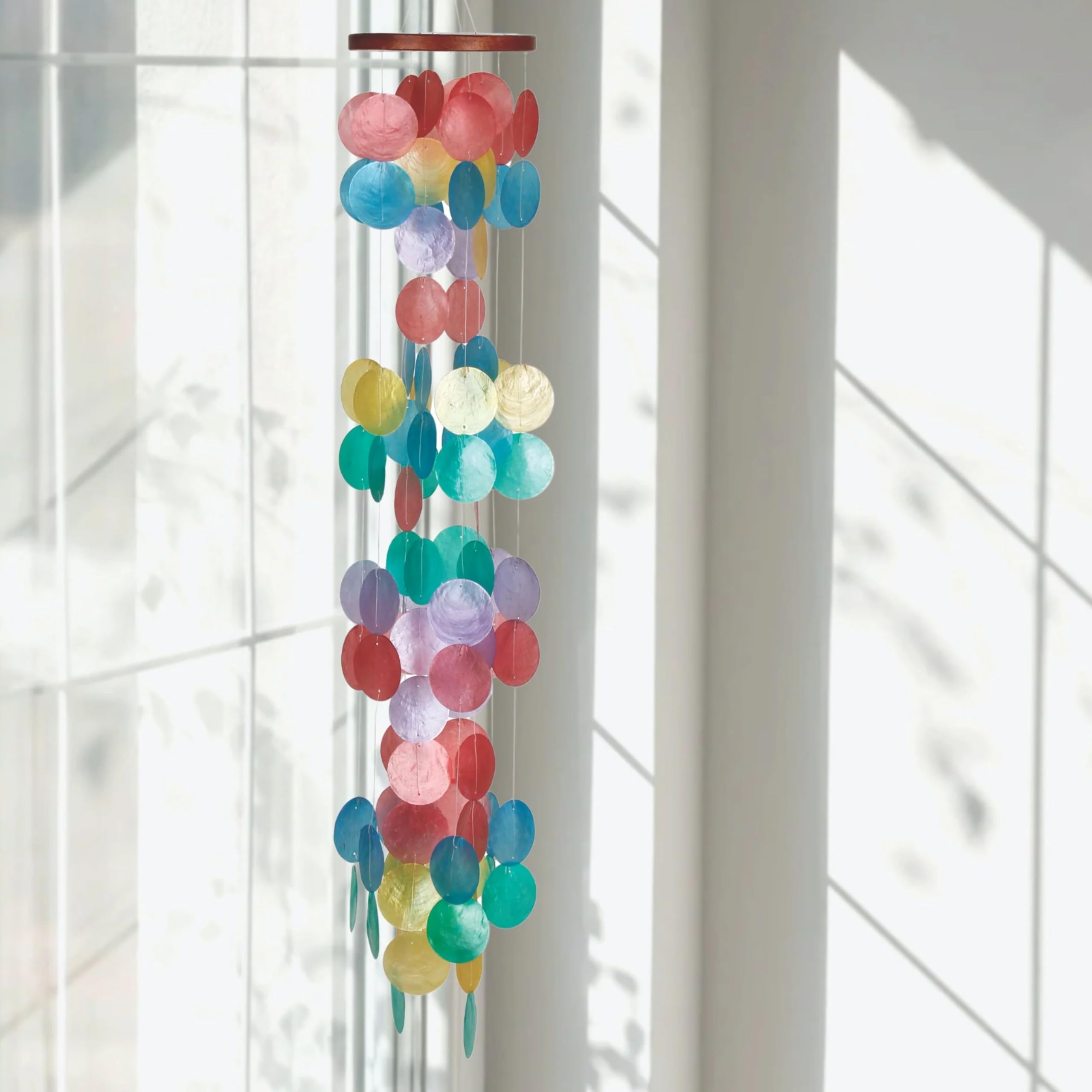 Woodstock Chimes capiz shells dancing in breeze for outdoor ambience.