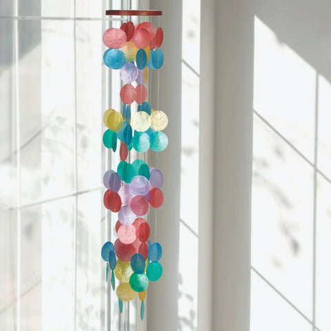 Woodstock Chimes capiz shells dancing in breeze for outdoor ambience.