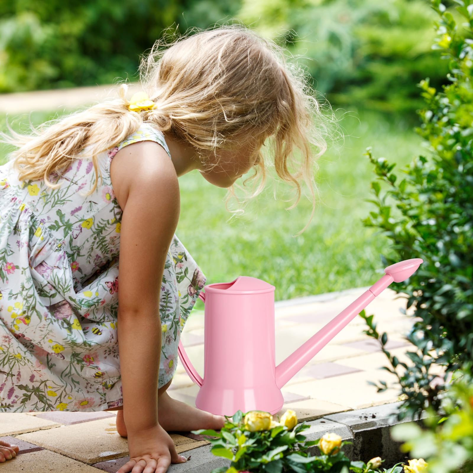 XXXFLOWER pink watering can on a bright windowsill with green plants.