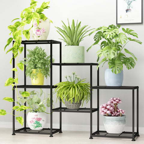 YUJCHMTZN three-tier metal plant stand displaying multiple pots in a living room.