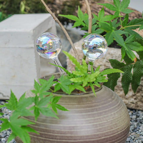 zHzHGuo iridescent globe decorates a shelf with greenery.