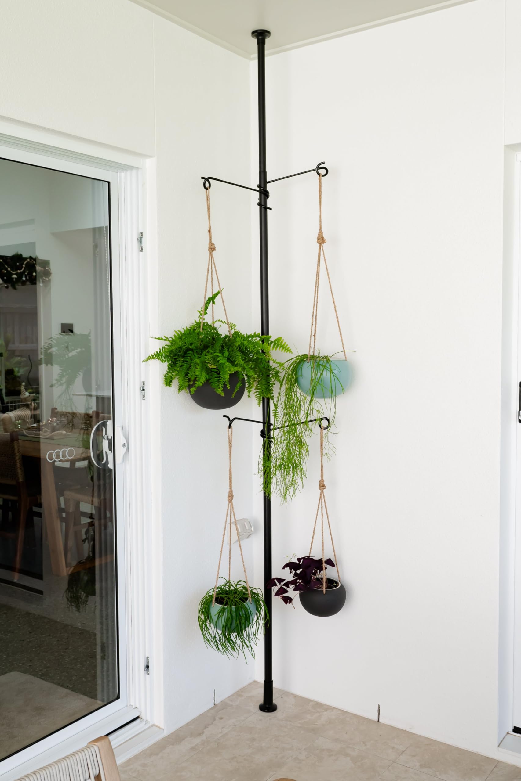 Zononoca tension rod plant stand hanging plants in a compact indoor corner